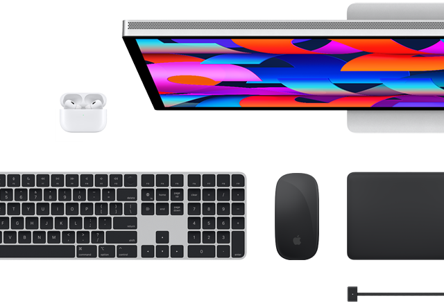 Accessoires Mac vus d’en haut : Studio Display, Magic Keyboard, Magic Mouse, Magic Trackpad, AirPods et câble de charge MagSafe